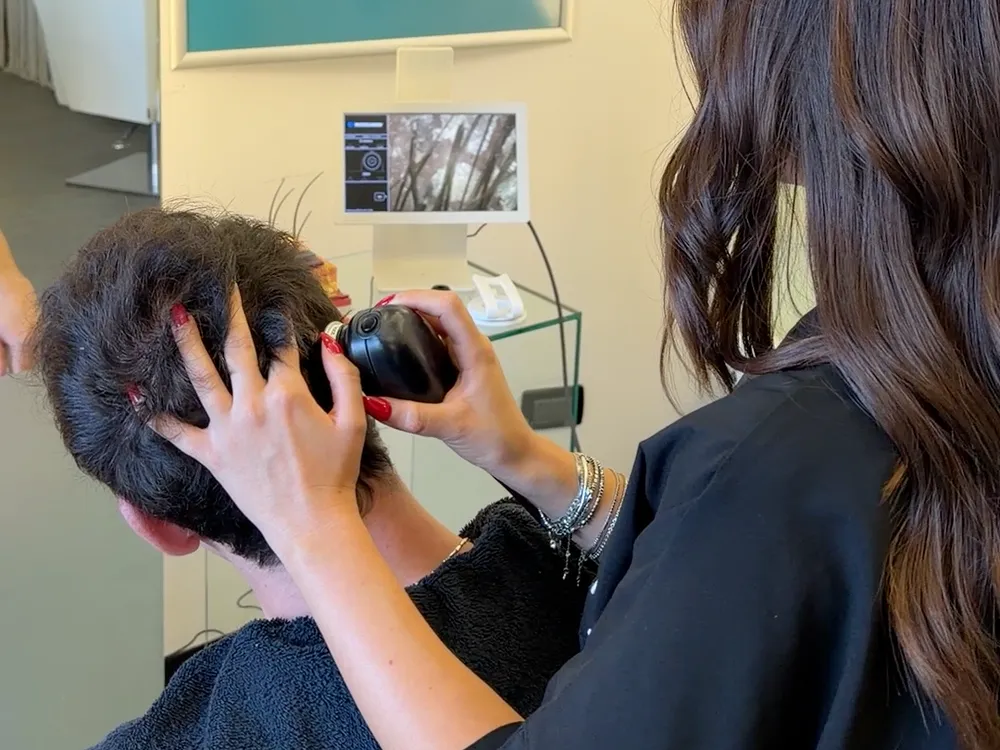 La microcamera appoggiata sulla testa del cliente durante la diagnosi